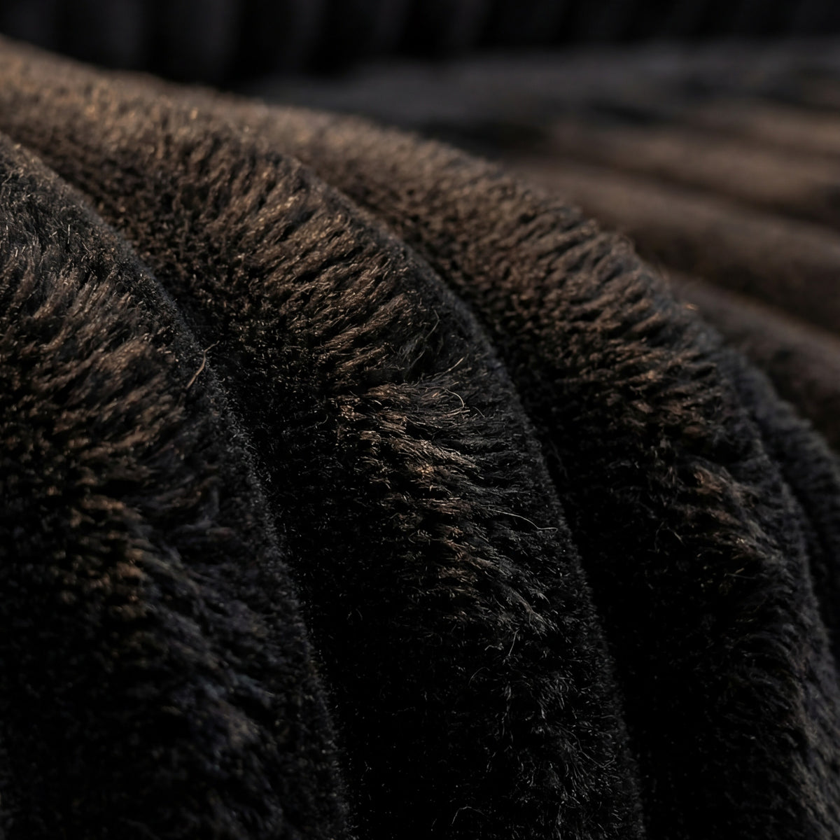 Detail view of Minky Black chaise lounger, showing fabric texture